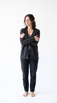 Woman hugging herself with arms crossed, looking away thoughtfully