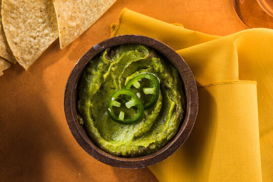 Traditional mexican dip or sauce guacamole in a rustic bowl