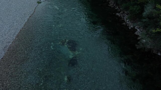 Static Aerial High Angle View of Clear Emerald Green Neretva River Flowing Over Pebbled Riverbed Bosnia