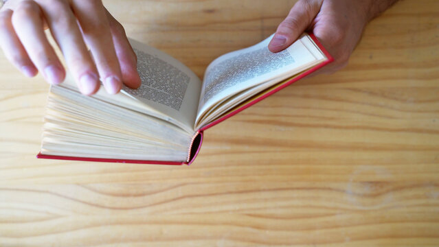 Top view shot of hands reading book