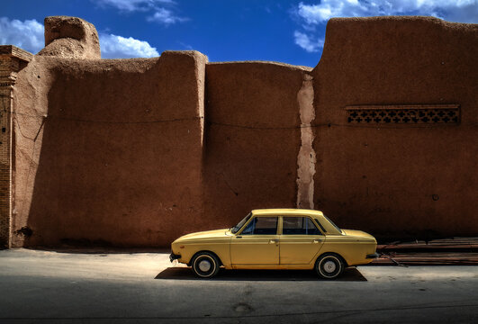old car in the street , urban landscape , travel , middel east , old city ,ochre rammed earth wall ,auto , mobility ,