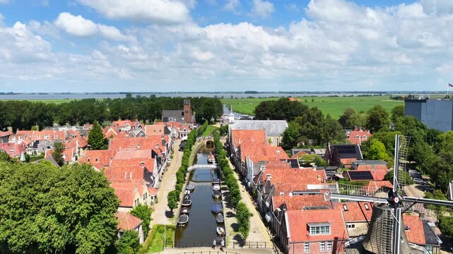 Aerial view of a historic canal town with windmill and landmarks in the Netherlands
