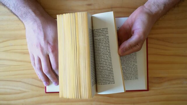 Top view shot of hands scrolling through book pages fast