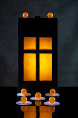 Silhouette of a glowing window, orange balls on a dark background © i_valentin