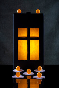 Silhouette of a glowing window, orange balls on a dark background