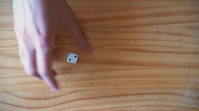 Luck and gambling concept. Dice with number two over wooden table