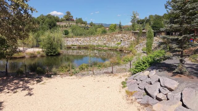 Scenic Artificial Lake surrounded by Green Nature and Stone Wall at Resort | Aerial View