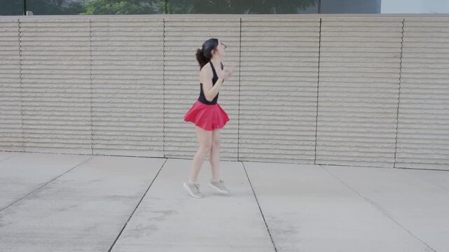 Energetic woman dancing joyfully outdoors in slow motion