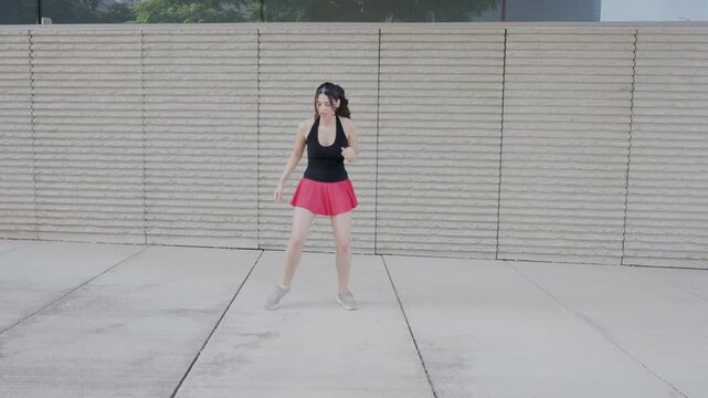 Joyful young woman dancing outdoors in slow motion