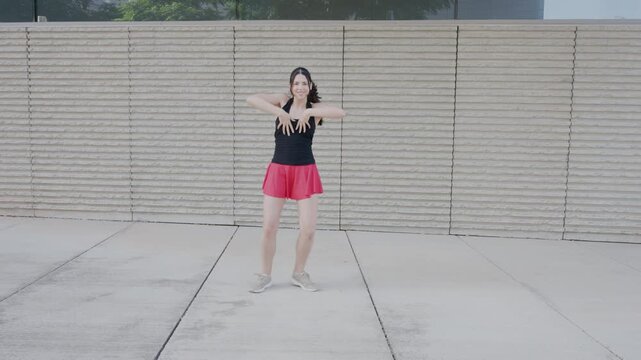 Young woman dancing and spinning outdoors in slow motion