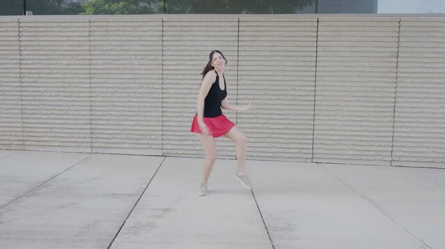 Joyful energetic woman dancing outside in slow motion