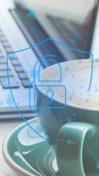 Animation of security padlock icon against mid section of woman using laptop at a cafe