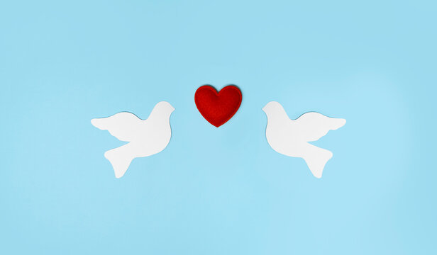 White doves and red heart symbolizing reconciliation, forgiveness, peace and harmonious relationships for International Day of Peace