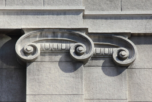 Stylized stone Ionic capital with scroll volutes on building facade