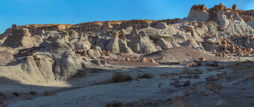 Beautiful wide panoramic view of unique natural sandstone hoodoo rock formations in desert at sunset