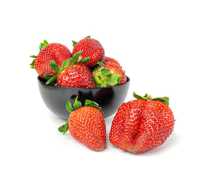 Fresh strawberry isolated, whole ripe straw berry, red juicy imperfect strawberri with green leaves