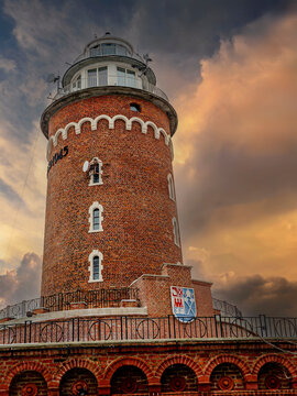 Historic Brick Lighthouse Tower at Sunset With Dramatic Sky and Maritime Beacon Overlooking Coast, Kolobrzeg, Poland
