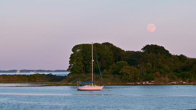 Groton, Connecticut, USA &ndash; Full Sturgeon Moon Over Sailboat at Golden Hour