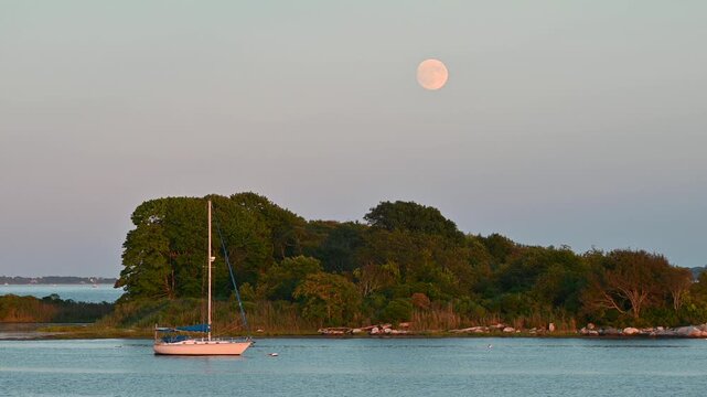 Groton, Connecticut, USA &ndash; Full Sturgeon Moon Over Sailboat at Golden Hour