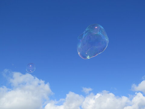Bulles de savon transparentes flottant dans un ciel bleu nuageux