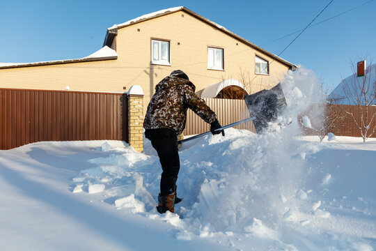 Person shovels snow from front yard