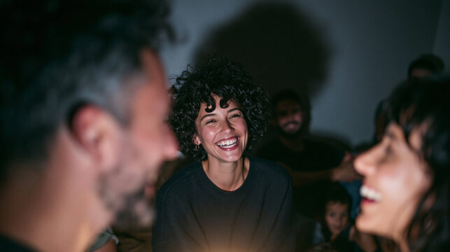 Happy Young Woman Laughing with Friends at Night Gathering