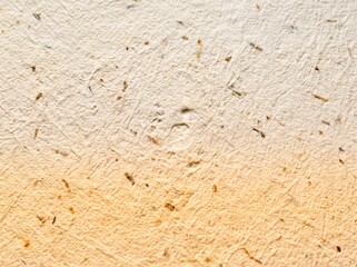 Fototapeta premium Recycled beige handmade paper texture featuring organic fiber flecks and subtle warm gradient lighting closeup detail