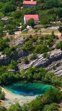 Aerial view of the Cetina River spring in Croatia, a karst water source with turquoise water surrounded by rocky landscape and greenery