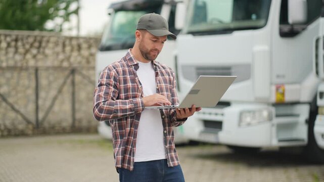 Truck driver managing fleet logistics using a laptop