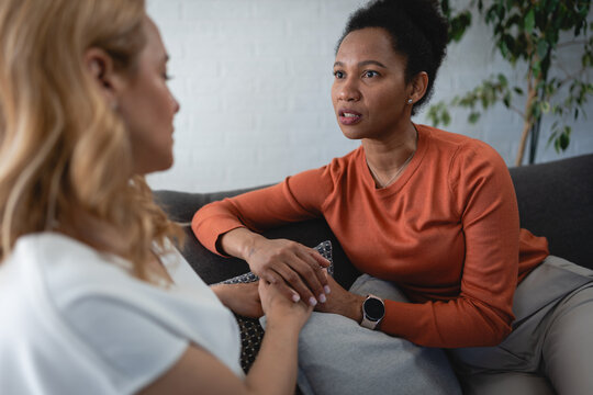 Female counselor showing empathy and compassion while supporting an emotional woman during an individual therapy session