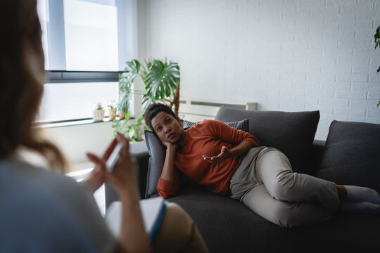 Woman experiencing emotional distress while speaking with a psychotherapist during a private counseling session in a comfortable setting