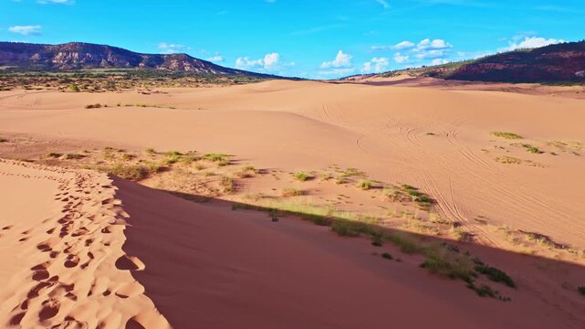 Golden sunset light glows across the panoramic view from atop a Coral Pink Sand Dunes State Park dune in Utah
