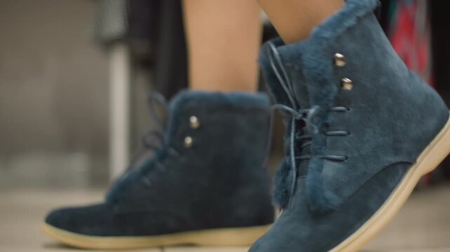 Close up of blue suede boots with fur trim and laces shown from various angles to highlight texture and design details. Boots are displayed on neutral background in soft lighting emphasizing