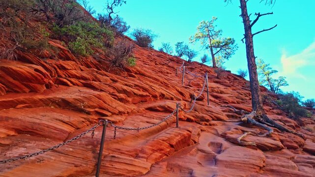 Golden sunrise light glows over the chained trail leading to Angels Landing in Zion National Park