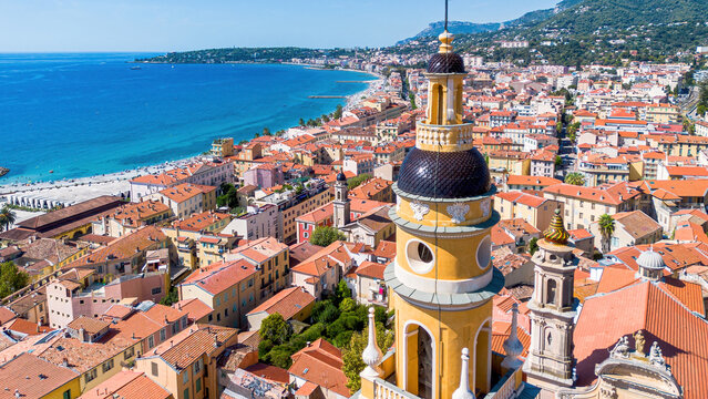 Aerial drone view of the bell tower of the Basilica of Saint-Michel in front of Borrigo Beach in Menton on the coast of the Mediterranean Sea in the French Riviera