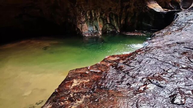 A scenic stream flows through water pools within the iconic Subway formation in Zion National Park