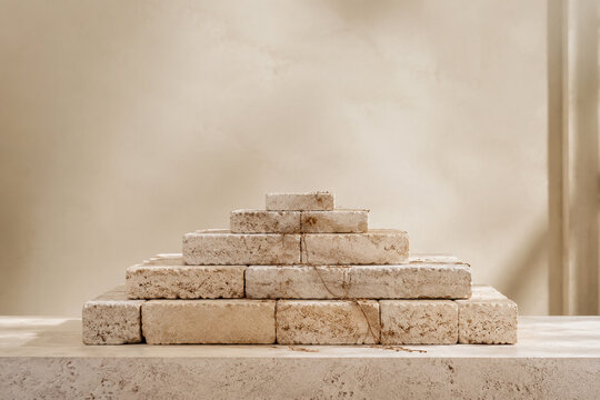 Stepped limestone ziggurat sculpture with dry vine tendrils on stone plinth, heritage and retail display concept