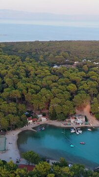 FKK Naturist Baldarin Campsite In Punta Kriza On Cres Island, Croatia, Filmed By Drone During A Beautiful Summer Evening. Aerial Views Show Campervans, Motorhomes, Coastal Nature at Sunset