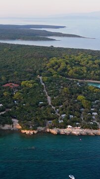 FKK Naturist Baldarin Campsite In Punta Kriza On Cres Island, Croatia, Filmed By Drone During A Beautiful Summer Evening. Aerial Views Show Campervans, Motorhomes, Coastal Nature at Sunset