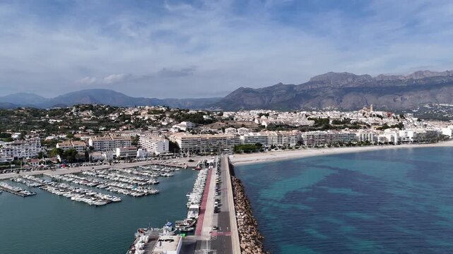 Aerial drone view of Altea marina, sandy beach, Mediterranean Sea and coastal town with the Sierra de Bernia mountains in Alicante, Spain.