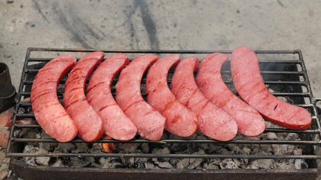 Turkish sucuk sausages grilling over hot coals on barbecue