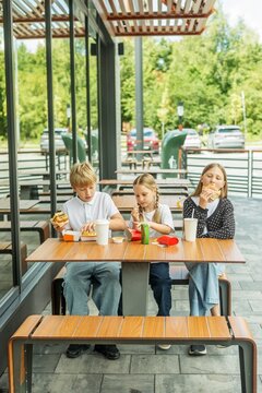 Three Children Enjoying Fast Food Together