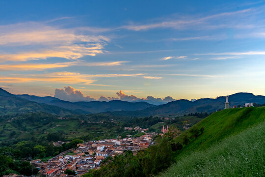 Aerial view of Jerico Antioquia colonial town at dusk with cathedral and hillside statue viewpoint