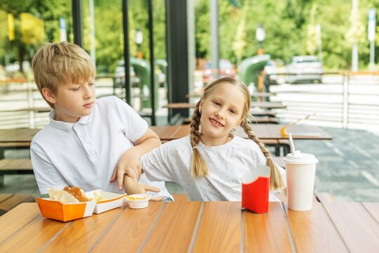 Older Brother and Younger Sister Fighting During Fast Food Meal