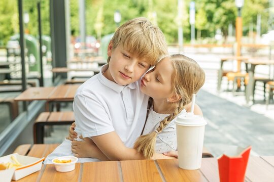 Younger Sister Kissing Older Brother During Sibling Bonding
