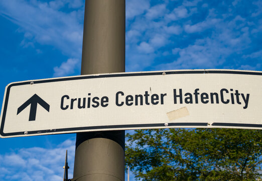 Directional sign pointing to the Cruise Center HafenCity in Hamburg, Germany under a blue sky