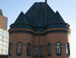 Historic brick building featuring turrets, windows, and slate roof under clear blue sky © 4kclips