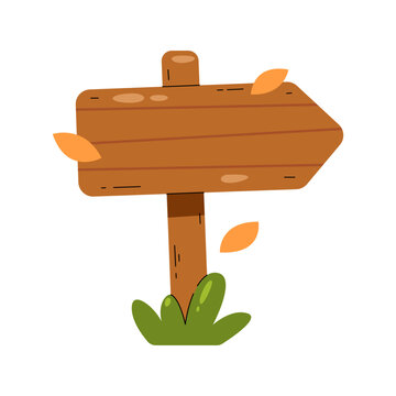 A wooden signpost with an arrow pointing to the right, surrounded by autumn leaves and grass. The signpost is made of wood and has a rustic appearance.