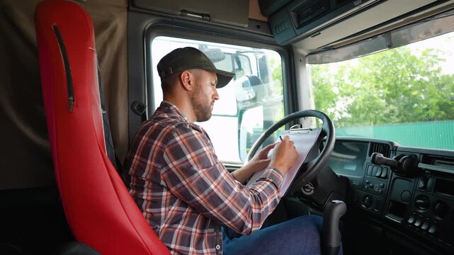Professional truck driver filling out paperwork in cabin
