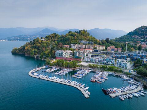 Aerial drone view of Porto Laveno marina in Laveno-Mombello town on the shores of Lake Maggiore in Italy, with picturesque lakeside scenery and Alpine mountains